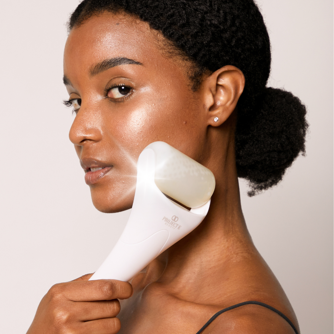 Close-up of a Project E Beauty ice roller being used to soothe and depuff the skin